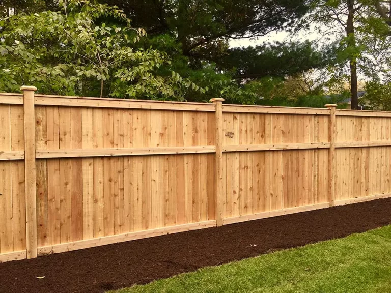 Professional fence installer working on a wood fence